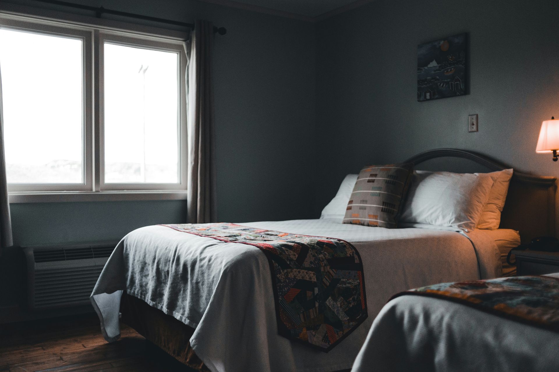a bed room with two beds and a lamp