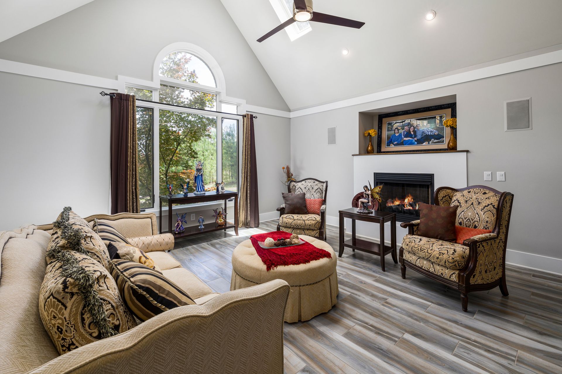 Bright living room with cozy seating, fireplace, and large windows.