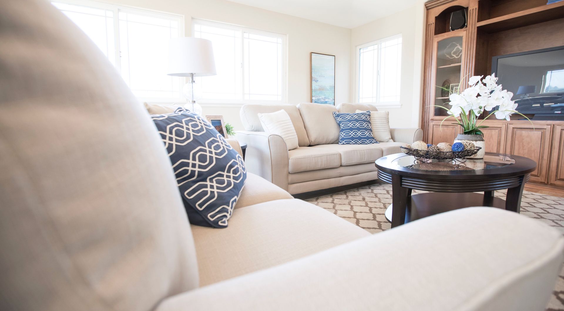 Bright and cozy modern living room interior with comfortable sofas, plush pillows, and elegant decor.